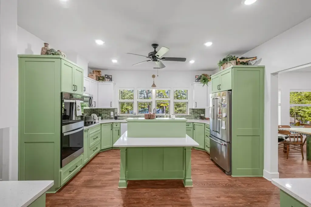 Kitchen with green cabinets, white countertops and a center island